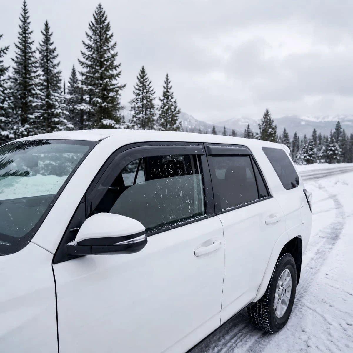 White Toyota 4Runner with smoke window visor rain guards installed in snowy weather