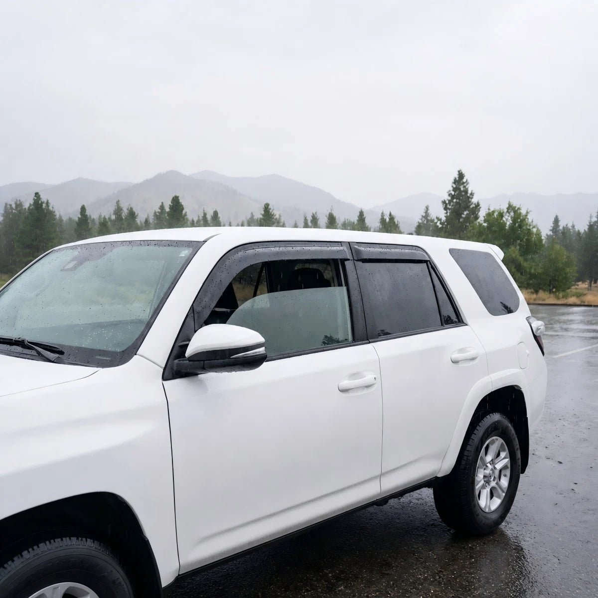 White Toyota 4Runner with smoke tape-on window vent deflectors installed in rainy weather